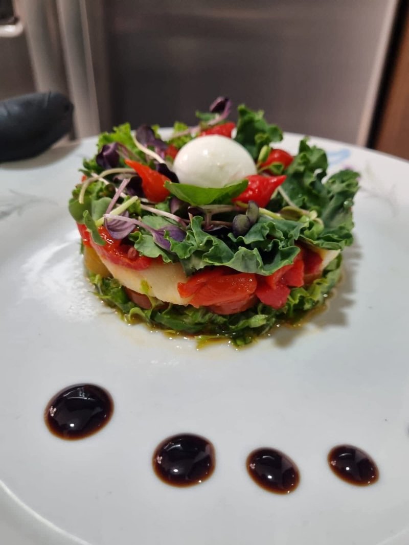 Una ensalada caprese gourmet servida para una cena privada de luna de miel