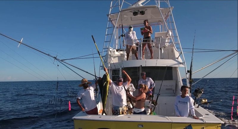 Una tripulación muestra un dorado en la cubierta de un bote de pesca frente a Quepos