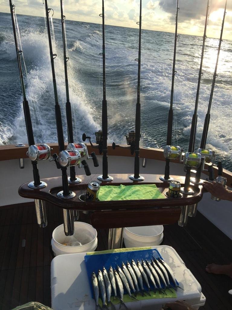 Cañas listas en la cubierta de un bote de pesca rumbo mar adentro al amanecer